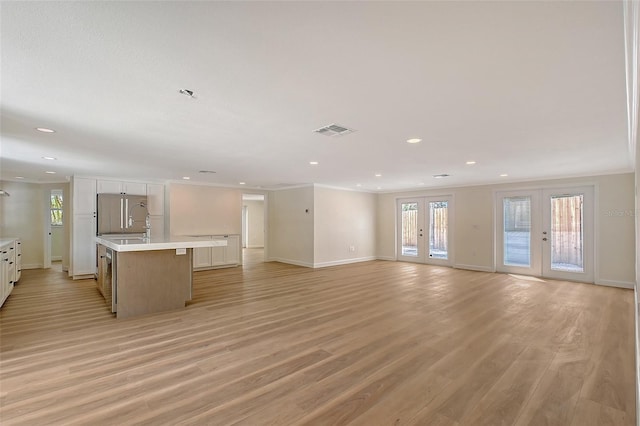 1203 Lyric Ln, Sarasota, FL 34242 - unfurnished living room featuring light wood finished floors, recessed lighting, crown molding, and french doors