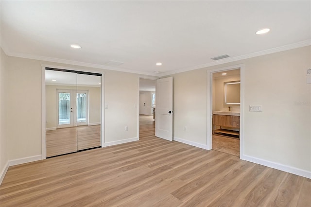 1203 Lyric Ln, Sarasota, FL 34242 - unfurnished bedroom with light wood-style flooring, recessed lighting, ornamental molding, ensuite bathroom, and a closet