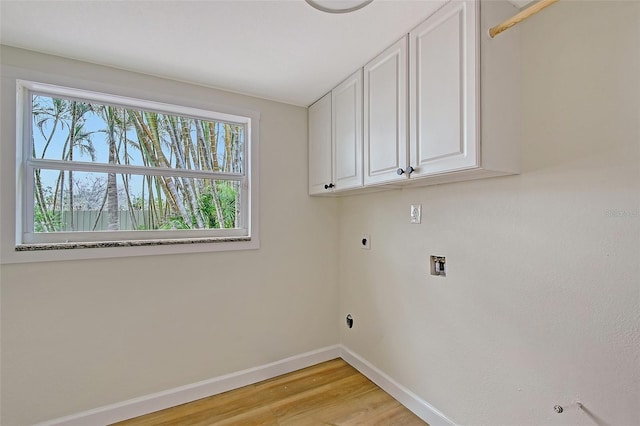 1203 Lyric Ln, Sarasota, FL 34242 - laundry area featuring hookup for an electric dryer, cabinet space, light wood finished floors, and washer hookup