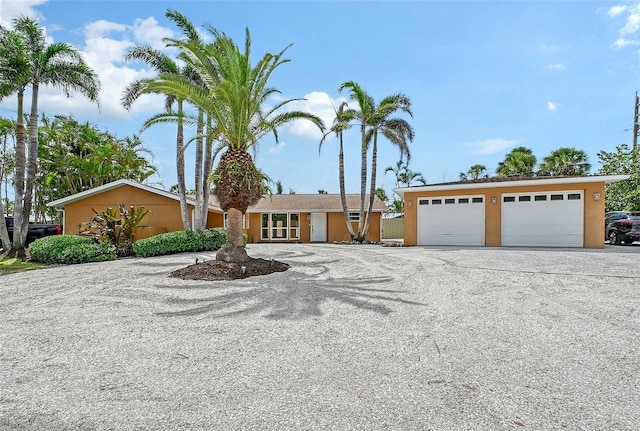 1203 Lyric Ln, Sarasota, FL 34242 - view of front of house with a garage, gravel driveway, and stucco siding