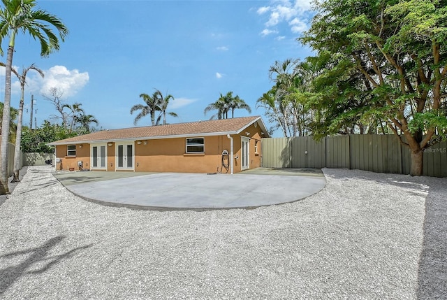 1203 Lyric Ln, Sarasota, FL 34242 - rear view of house with french doors, stucco siding, and a gate