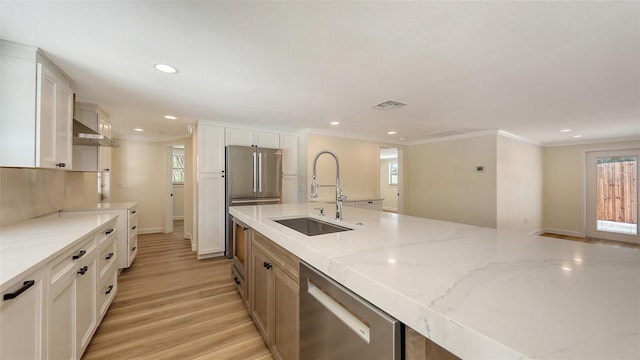 1203 Lyric Ln, Sarasota, FL 34242 - kitchen featuring appliances with stainless steel finishes, light wood-style floors, white cabinetry, light stone counters, and crown molding