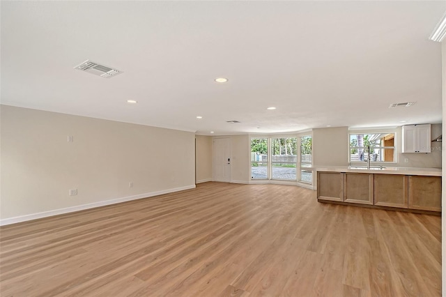 1203 Lyric Ln, Sarasota, FL 34242 - unfurnished living room featuring light wood-style floors and recessed lighting