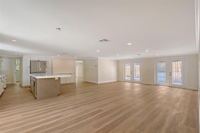 1203 Lyric Ln, Sarasota, FL 34242 - unfurnished living room with light wood-style floors, recessed lighting, crown molding, and french doors