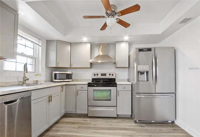 222 Caddy Rd, Rotonda West, FL 33947 - kitchen featuring appliances with stainless steel finishes, wall chimney range hood, a tray ceiling, and light countertops
