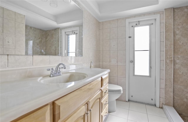 222 Caddy Rd, Rotonda West, FL 33947 - full bathroom featuring tile walls, vanity, a tray ceiling, and tile patterned flooring