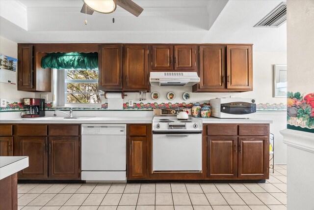 5600 Beach Way Dr Unit 201, Sarasota, FL 34242 - kitchen with white appliances, under cabinet range hood, light countertops, light tile patterned flooring, and ornamental molding