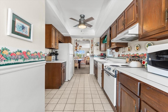 5600 Beach Way Dr Unit 201, Sarasota, FL 34242 - kitchen with under cabinet range hood, white appliances, a ceiling fan, a tray ceiling, and light countertops