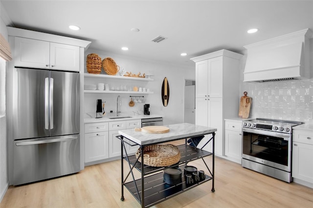 404 Bayshore Rd, Nokomis, FL 34275 - kitchen with appliances with stainless steel finishes, custom exhaust hood, a sink, backsplash, and white cabinetry