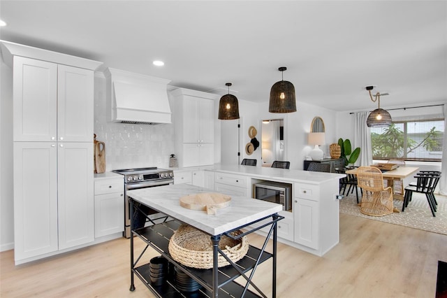404 Bayshore Rd, Nokomis, FL 34275 - kitchen with appliances with stainless steel finishes, custom exhaust hood, a peninsula, light wood-type flooring, and light countertops
