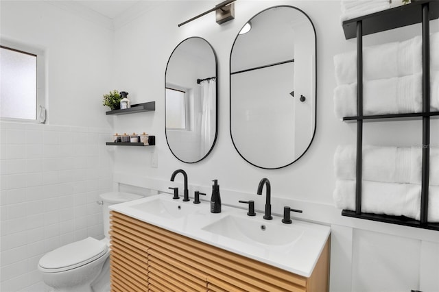 404 Bayshore Rd, Nokomis, FL 34275 - bathroom featuring toilet, tile walls, healthy amount of natural light, double vanity, and ornamental molding