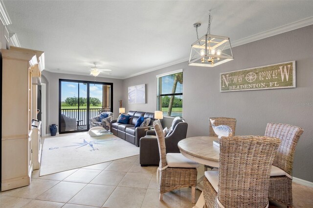 6515 Grand Estuary Trl Unit 208, Bradenton, FL 34212 - dining area with crown molding, a chandelier, light tile patterned flooring, ceiling fan, and light carpet