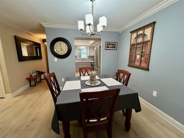 3272 Lake Bayshore Dr Unit 515, Bradenton, FL 34205 - dining space featuring light wood-style floors, a chandelier, baseboards, and crown molding