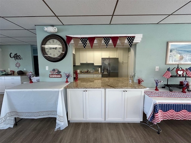 3272 Lake Bayshore Dr Unit 515, Bradenton, FL 34205 - kitchen featuring black fridge with ice dispenser, a paneled ceiling, dark wood finished floors, a peninsula, and white cabinets
