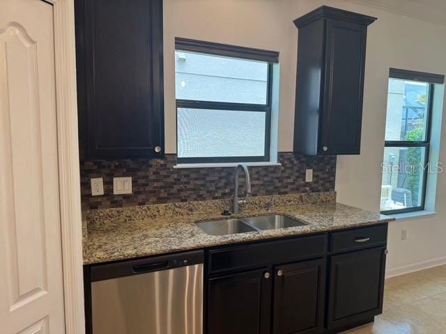 4077 River Bank Way, Punta Gorda, FL 33980 - kitchen with stainless steel dishwasher, a sink, baseboards, tasteful backsplash, and light stone counters