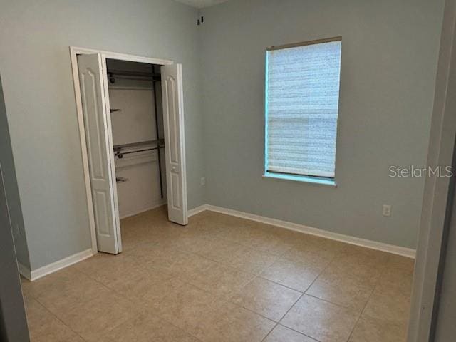 4077 River Bank Way, Punta Gorda, FL 33980 - unfurnished bedroom featuring a closet, light tile patterned floors, and baseboards