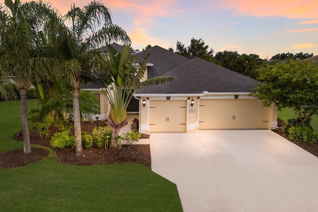 12015 Forest Park Cir, Bradenton, FL 34211 - view of front of house with an attached garage, roof with shingles, a front lawn, concrete driveway, and stucco siding