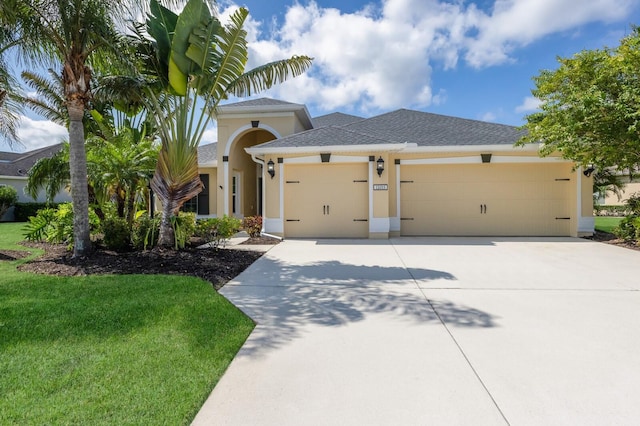 12015 Forest Park Cir, Bradenton, FL 34211 - view of front of house with an attached garage, concrete driveway, stucco siding, a front yard, and roof with shingles