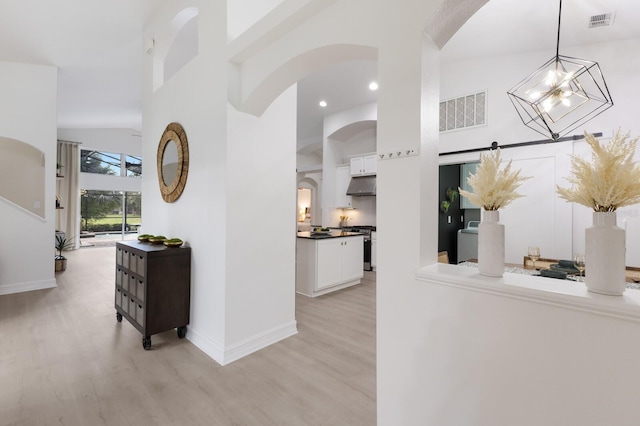 12015 Forest Park Cir, Bradenton, FL 34211 - hallway featuring light wood-style flooring, arched walkways, high vaulted ceiling, baseboards, and recessed lighting