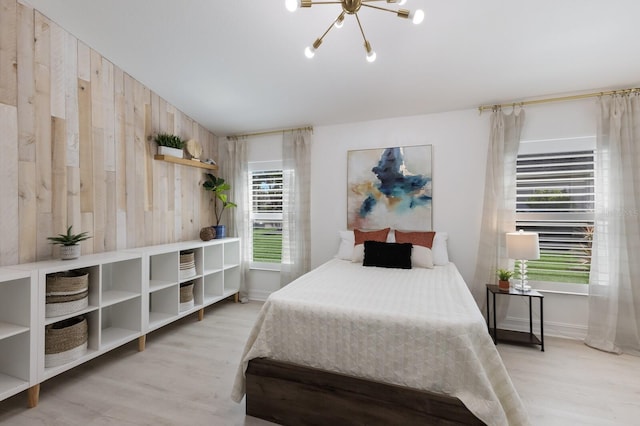 12015 Forest Park Cir, Bradenton, FL 34211 - bedroom with light wood-type flooring, a chandelier, wooden walls, and baseboards