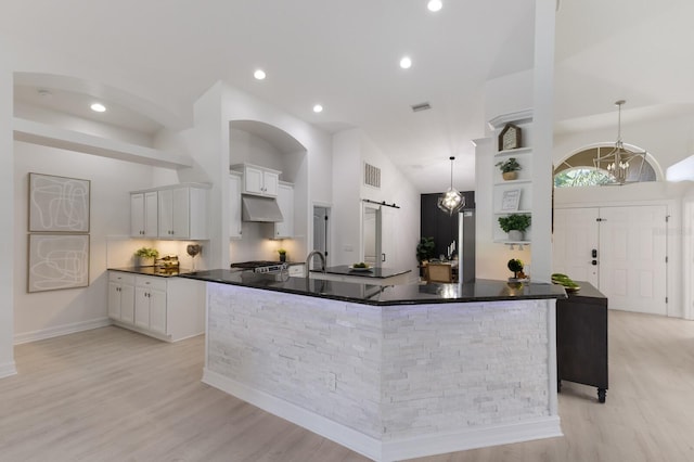 12015 Forest Park Cir, Bradenton, FL 34211 - kitchen with under cabinet range hood, light wood-style floors, white cabinetry, recessed lighting, and high vaulted ceiling
