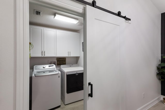 12015 Forest Park Cir, Bradenton, FL 34211 - washroom featuring cabinet space, washing machine and dryer, a barn door, and baseboards
