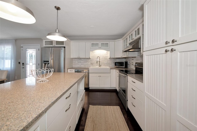 2363 Milford Cir, Sarasota, FL 34239 - kitchen featuring stainless steel appliances, under cabinet range hood, a sink, white cabinets, and glass insert cabinets