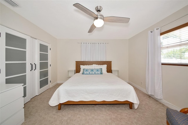 2363 Milford Cir, Sarasota, FL 34239 - bedroom with light colored carpet, a ceiling fan, french doors, and baseboards
