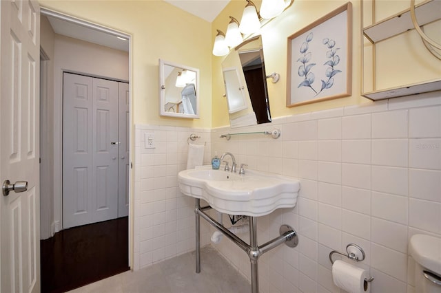 2363 Milford Cir, Sarasota, FL 34239 - bathroom with tile walls, a wainscoted wall, toilet, and tile patterned floors