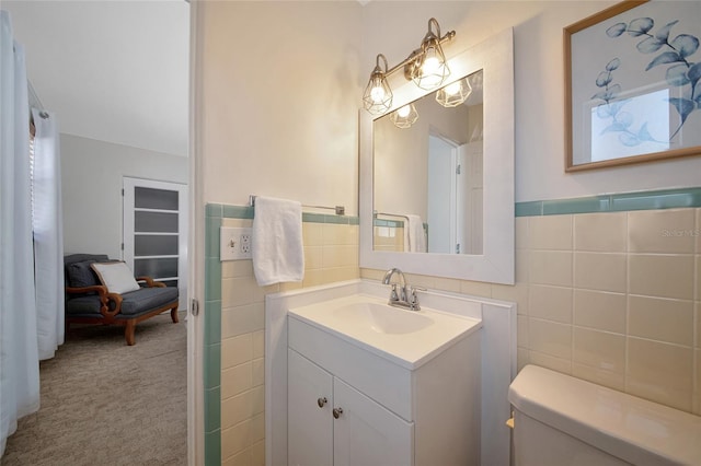 2363 Milford Cir, Sarasota, FL 34239 - bathroom with tile walls, vanity, toilet, and a wainscoted wall