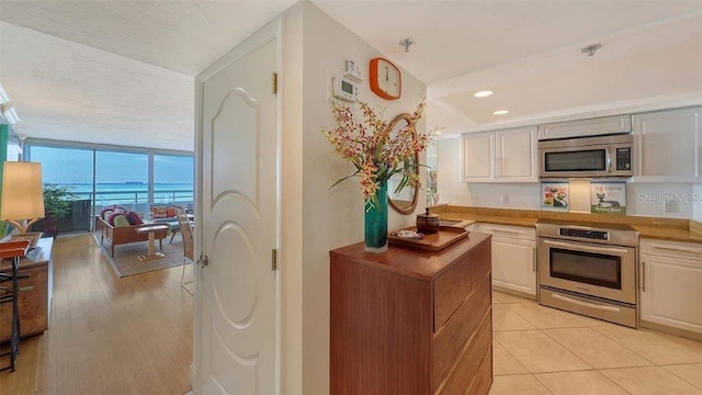 988 Blvd Of The Arts Unit 1016, Sarasota, FL 34236 - kitchen featuring appliances with stainless steel finishes, floor to ceiling windows, and light tile patterned flooring
