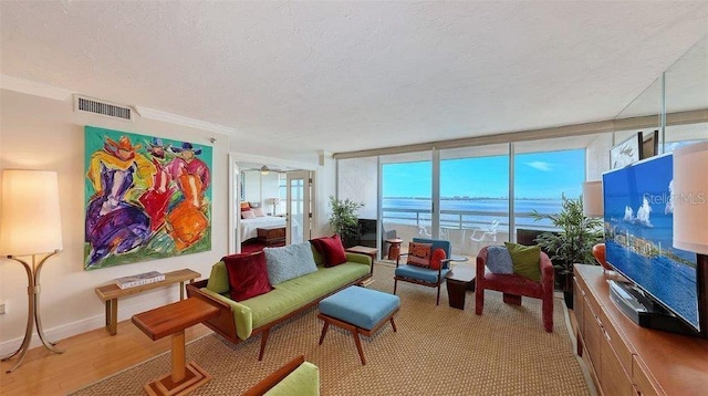 988 Blvd Of The Arts Unit 1016, Sarasota, FL 34236 - living room with a textured ceiling, a ceiling fan, ornamental molding, and baseboards