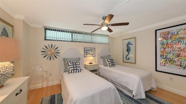 988 Blvd Of The Arts Unit 1016, Sarasota, FL 34236 - bedroom with light wood-style flooring, baseboards, crown molding, and a ceiling fan