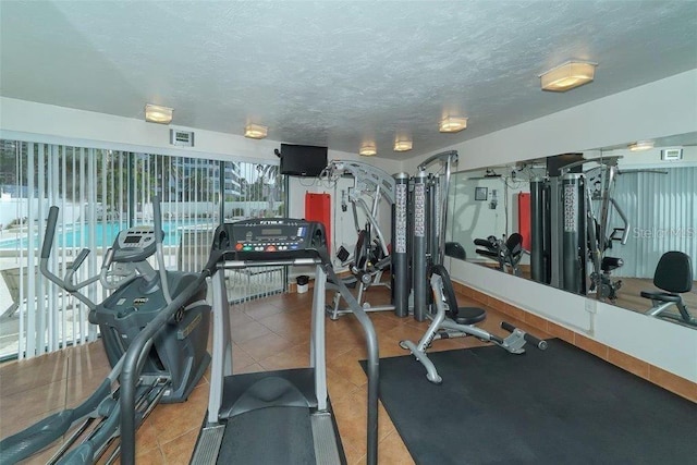 988 Blvd Of The Arts Unit 1016, Sarasota, FL 34236 - gym with a textured ceiling and tile patterned flooring