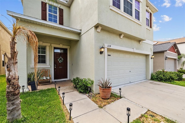 1234 Harbour Blue St, Ruskin, FL 33570 - view of exterior entry with stucco siding, a garage, and concrete driveway