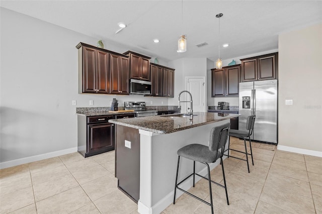 1234 Harbour Blue St, Ruskin, FL 33570 - kitchen featuring stainless steel appliances, a sink, a breakfast bar, dark stone countertops, and dark brown cabinets