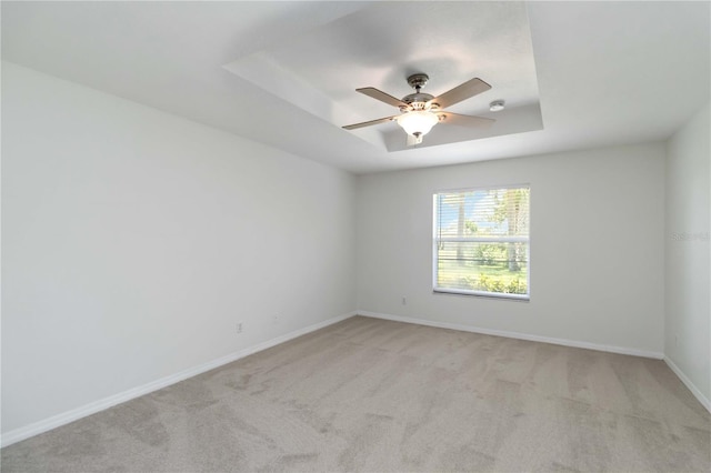 2199 Palm Ct, North Port, FL 34287 - spare room with a ceiling fan, light carpet, a tray ceiling, and baseboards