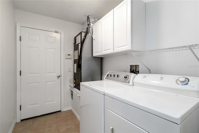 2199 Palm Ct, North Port, FL 34287 - washroom featuring washing machine and clothes dryer, baseboards, light tile patterned floors, and cabinet space