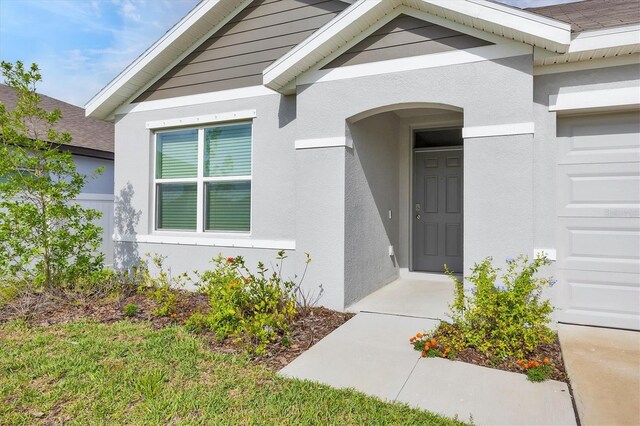 2105 Grand Flora Trl, Bradenton, FL 34208 - view of exterior entry featuring stucco siding and an attached garage