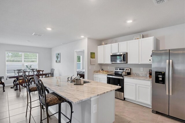 2105 Grand Flora Trl, Bradenton, FL 34208 - kitchen with stainless steel appliances, a sink, light tile patterned flooring, white cabinetry, and recessed lighting