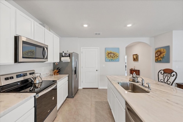 2105 Grand Flora Trl, Bradenton, FL 34208 - kitchen featuring stainless steel appliances, a sink, arched walkways, white cabinets, and recessed lighting
