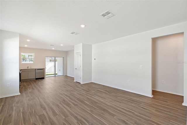 1643 35th St, Sarasota, FL 34234 - unfurnished living room with wood finished floors, baseboards, recessed lighting, and a sink