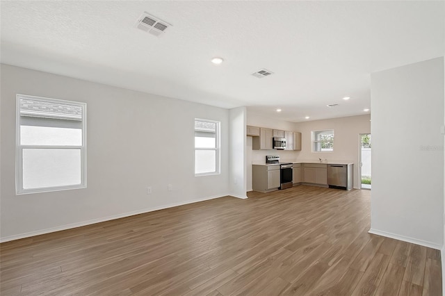 1643 35th St, Sarasota, FL 34234 - unfurnished living room featuring light wood finished floors, baseboards, recessed lighting, and a sink