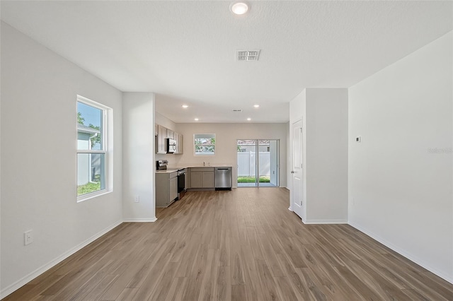 1643 35th St, Sarasota, FL 34234 - unfurnished living room featuring baseboards, light wood-style flooring, recessed lighting, and a sink