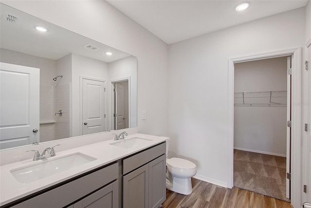 1643 35th St, Sarasota, FL 34234 - full bath featuring wood finished floors, double vanity, toilet, a walk in closet, and recessed lighting