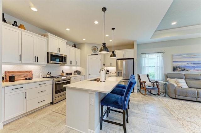 4625 Canoe Creek Ave, Parrish, FL 34219 - kitchen featuring appliances with stainless steel finishes, a sink, open floor plan, white cabinetry, and backsplash