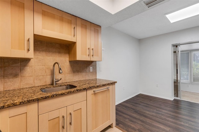 5356 Royal Palm Ave Unit 5356, Sarasota, FL 34234 - kitchen featuring a sink, dark wood-style flooring, backsplash, dark stone countertops, and baseboards