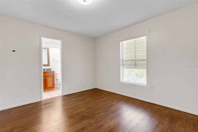 5356 Royal Palm Ave Unit 5356, Sarasota, FL 34234 - empty room featuring electric panel, light wood-type flooring, baseboards, and a textured ceiling