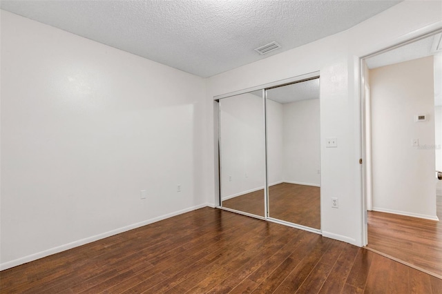 5356 Royal Palm Ave Unit 5356, Sarasota, FL 34234 - unfurnished bedroom with wood finished floors, a closet, a textured ceiling, and baseboards