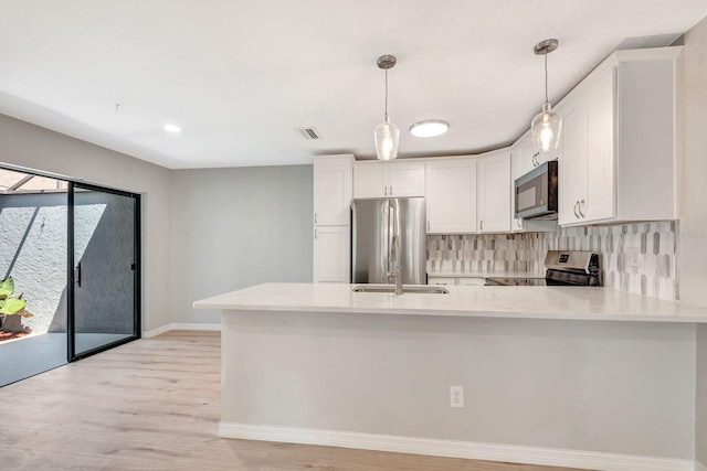 5192 Cedar Hammock Ln, Sarasota, FL 34232 - kitchen with appliances with stainless steel finishes, light countertops, baseboards, a peninsula, and recessed lighting